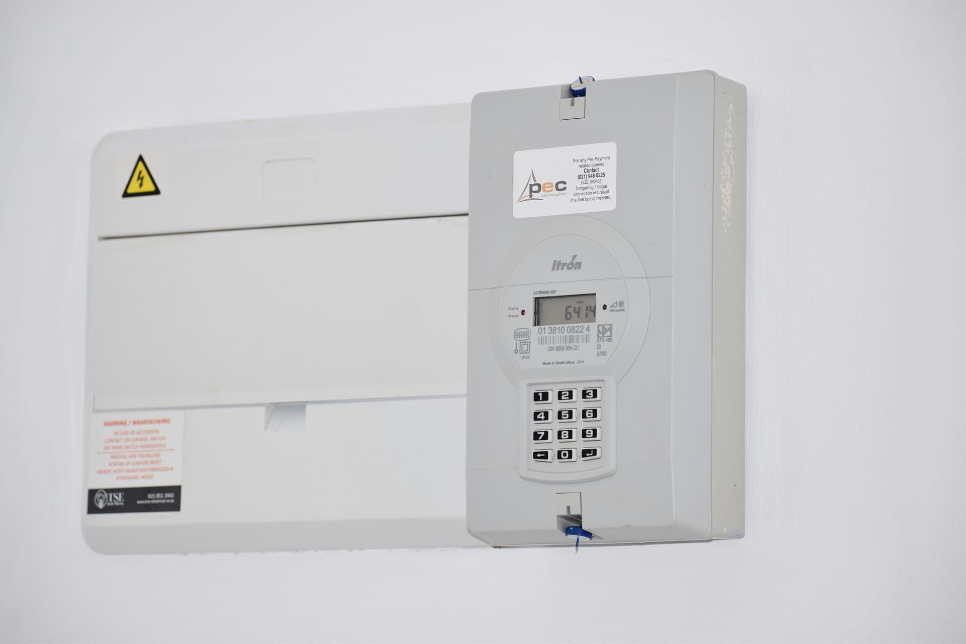 A residential electricity meter and service box mounted on an exterior wall